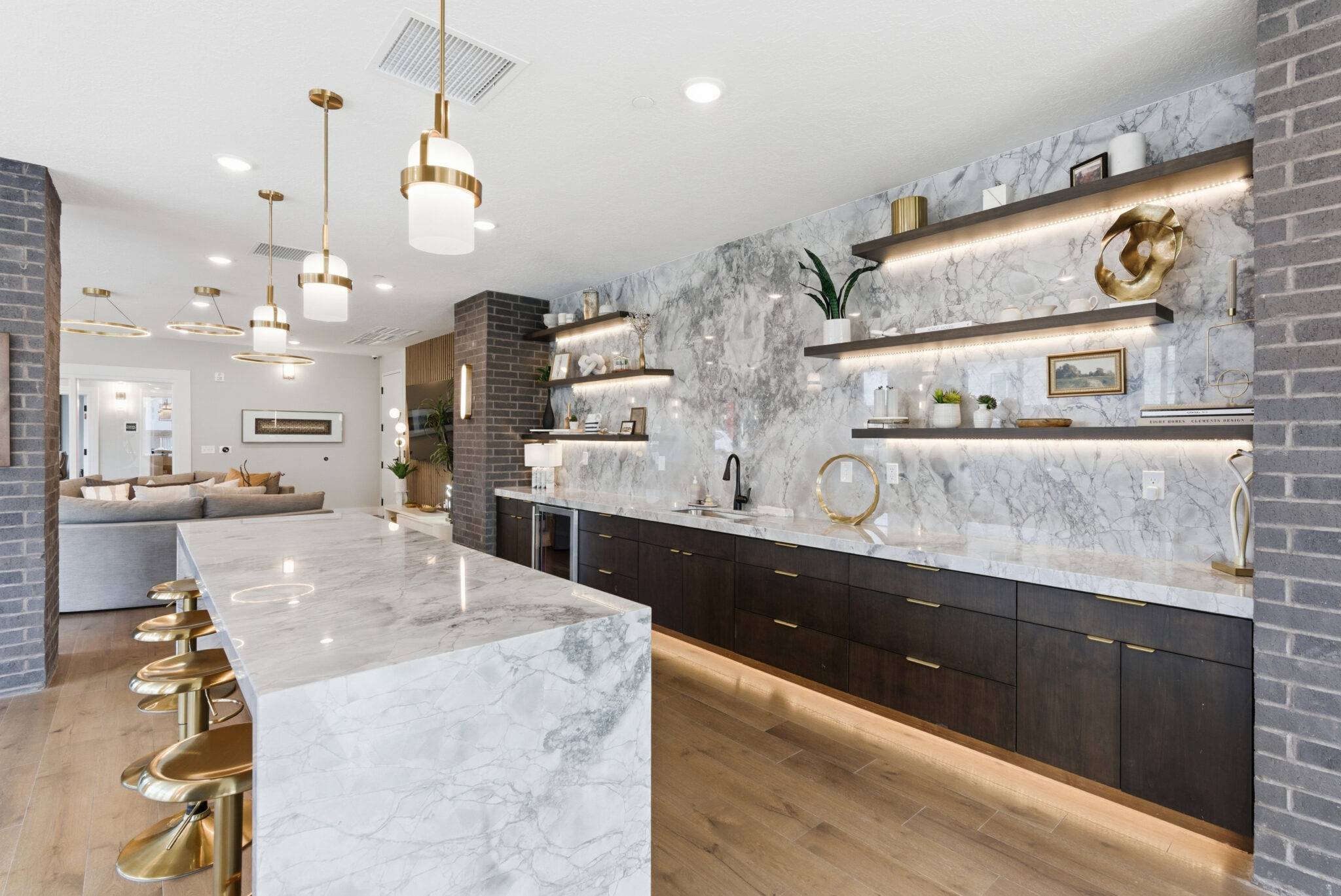 A modern kitchen featuring elegant marble countertops and stylish gold accents, designed by SCS Multifamily.