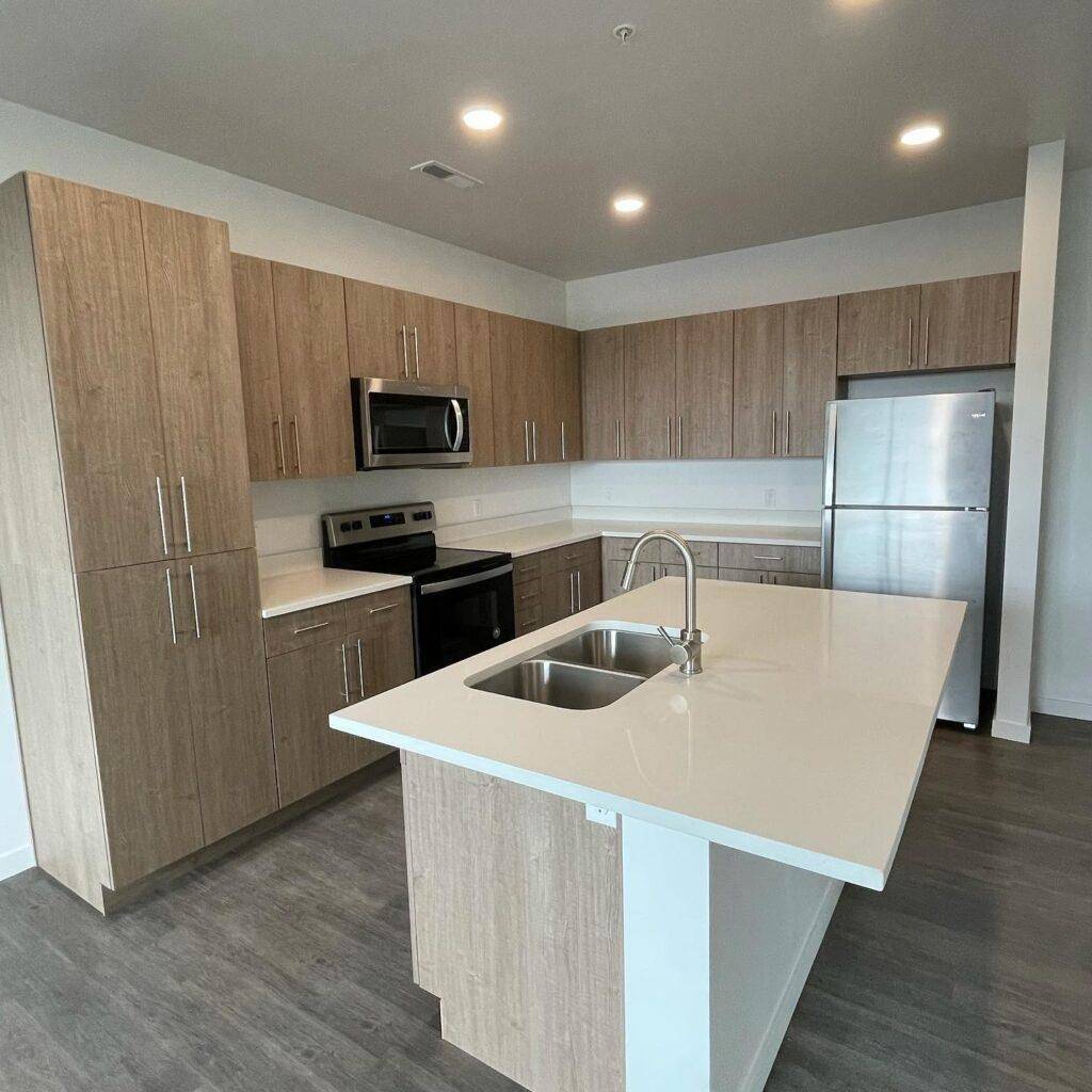 A contemporary kitchen showcasing sleek stainless steel appliances paired with elegant wood cabinets for a warm ambiance