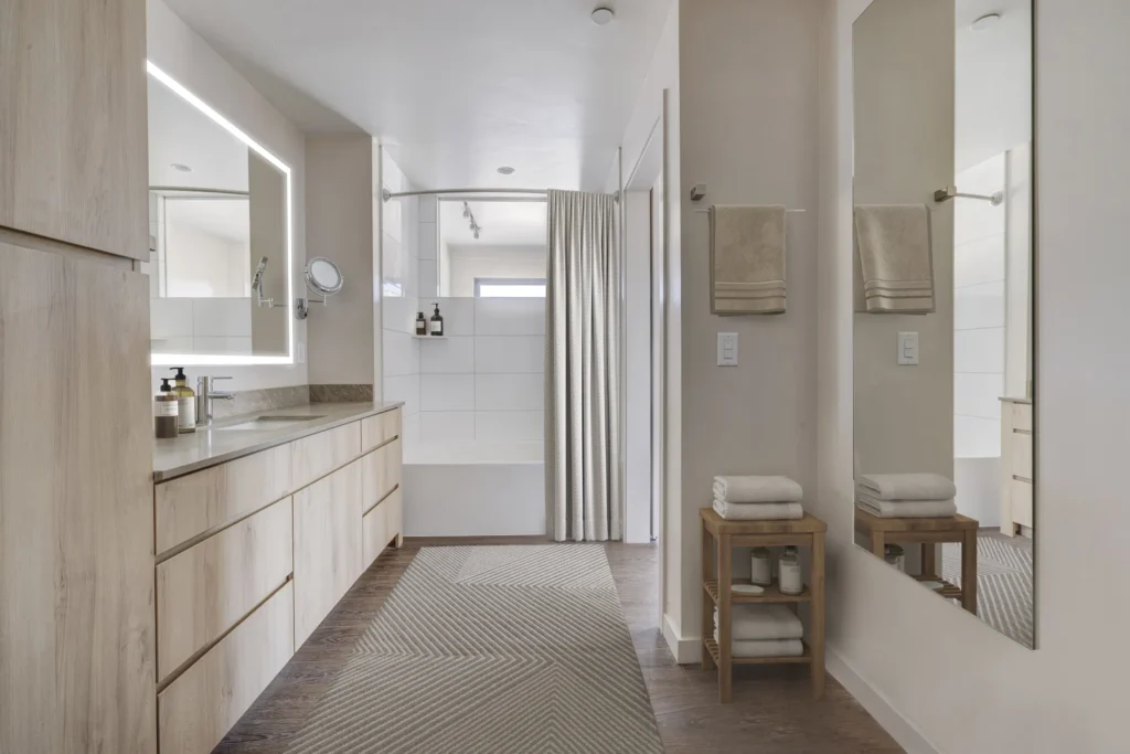 A bathroom featuring a wooden floor and white walls, designed by scs Multifamily.