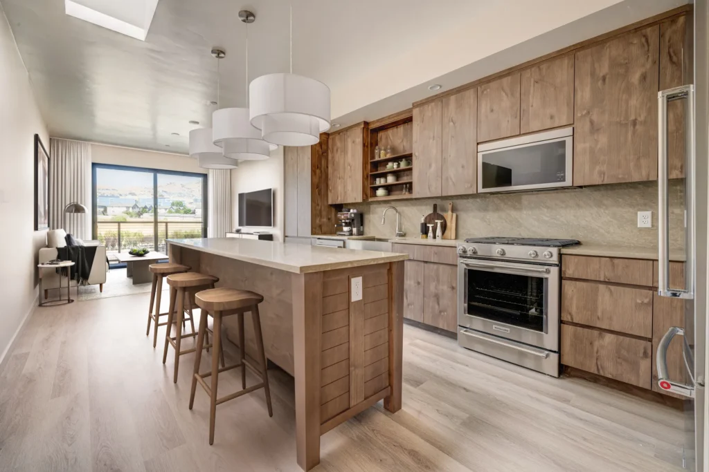 A modern kitchen featuring wooden cabinets and stainless steel appliances, designed by scs Multifamily.