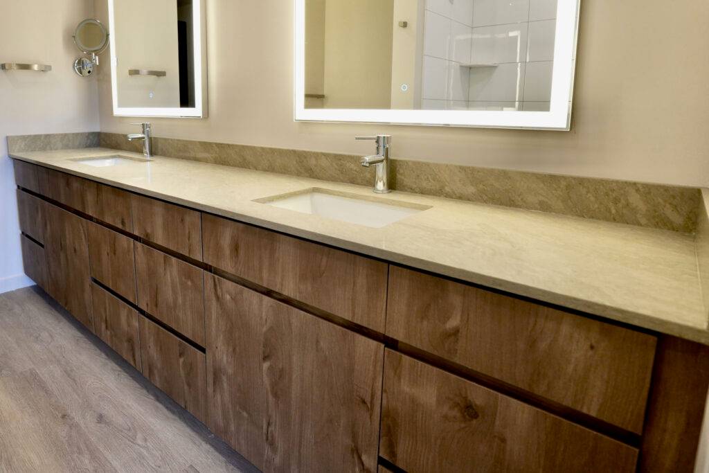 A modern bathroom featuring two sinks and a large mirror, designed by scs Multifamily.