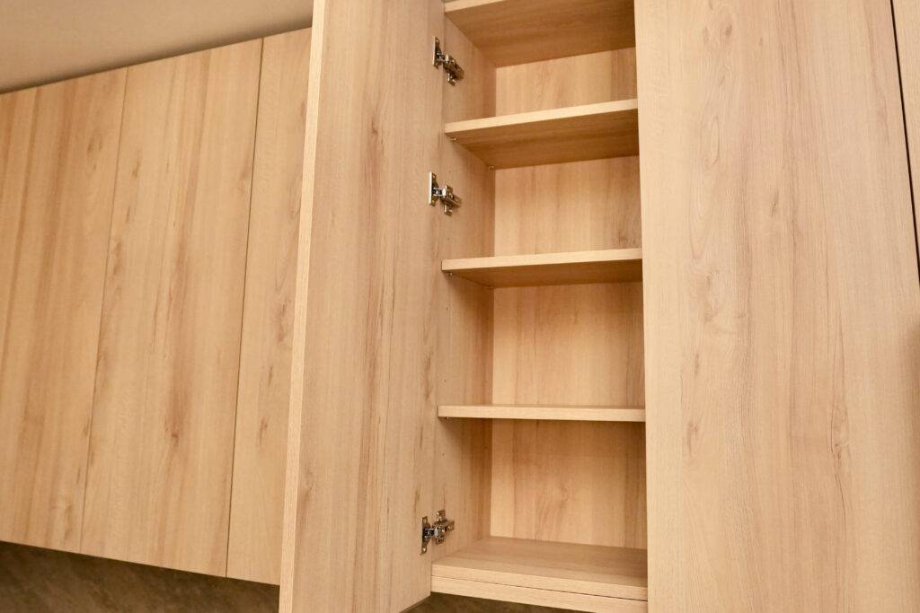 Kitchen cabinet with open shelves above a sink, showcasing a modern design by scs Multifamily.