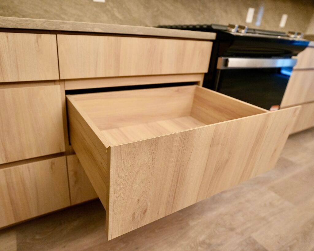 An open drawer in a kitchen, highlighting its contents, part of a design by scs Multifamily.