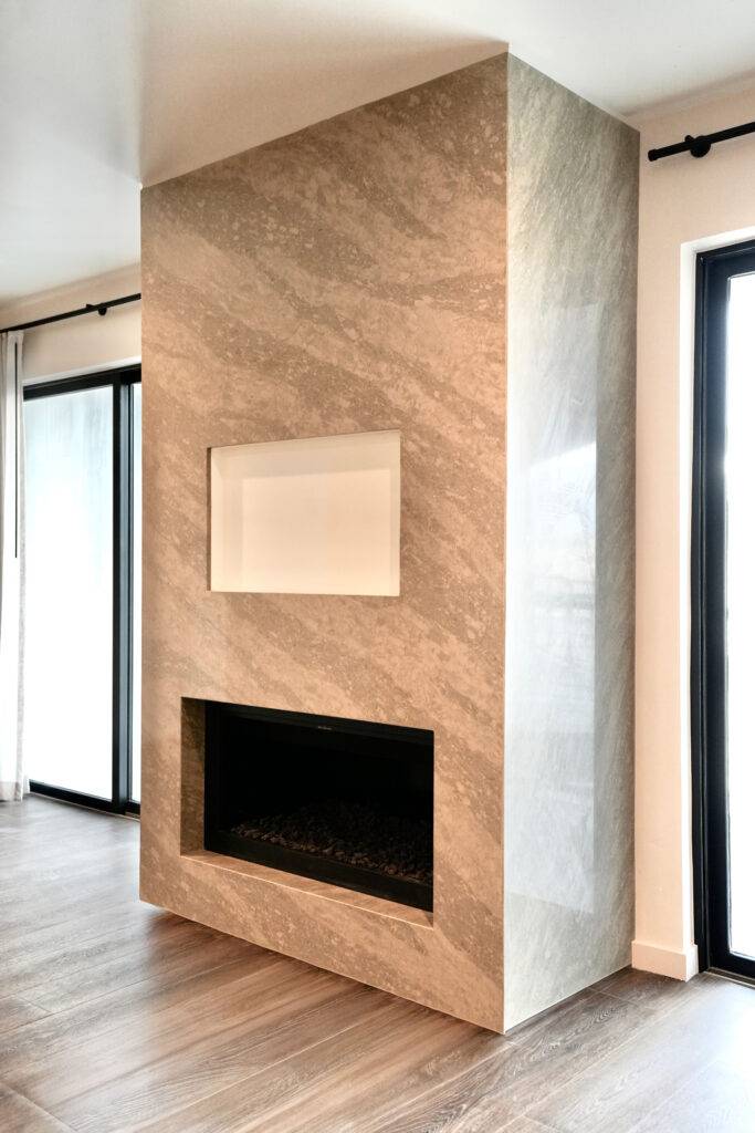 A spacious living room featuring a large fireplace and elegant hardwood floors, designed by scs Multifamily.