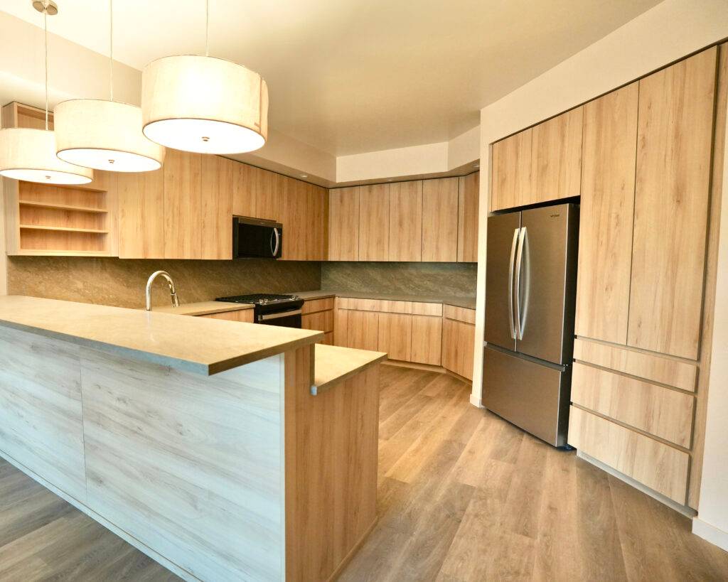 Stylish kitchen with wooden cabinetry and stainless steel appliances, showcasing scs Multifamily's design.