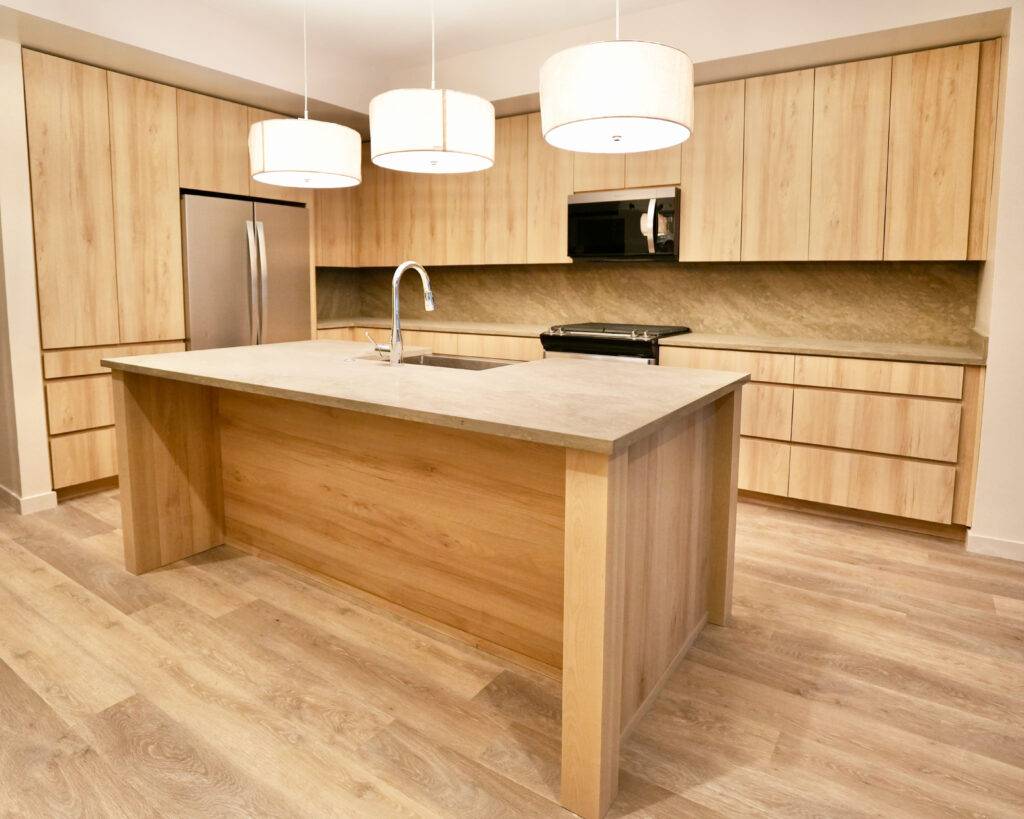 A kitchen featuring wooden cabinets and a central island, designed by SCS Multifamily.